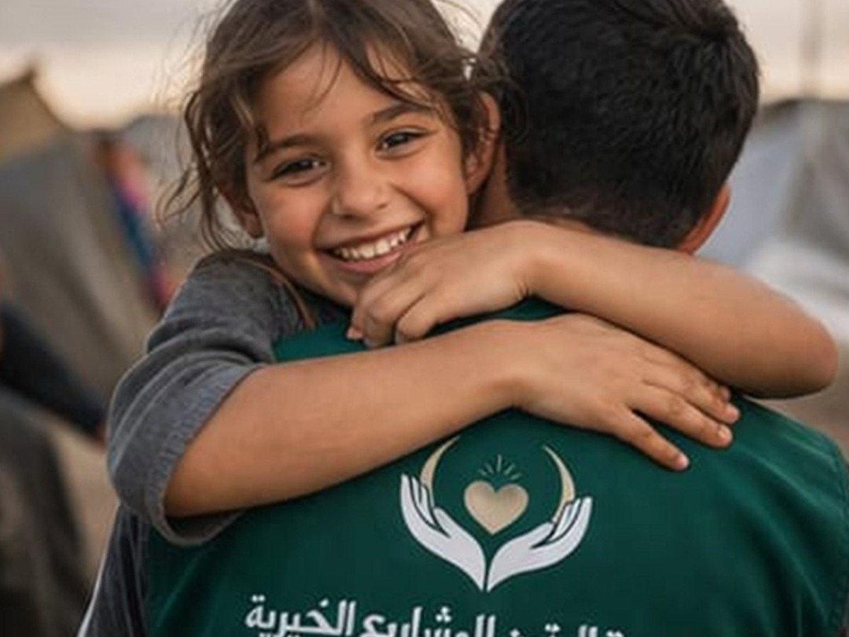 A child embracing an aid worker